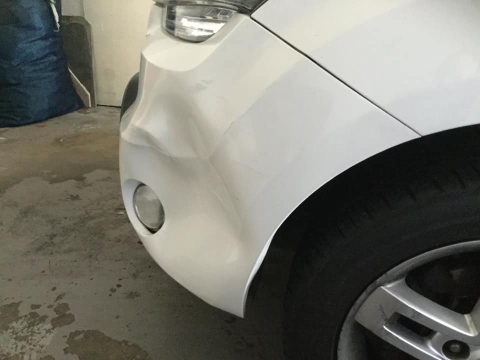 Before - White car bumper dent